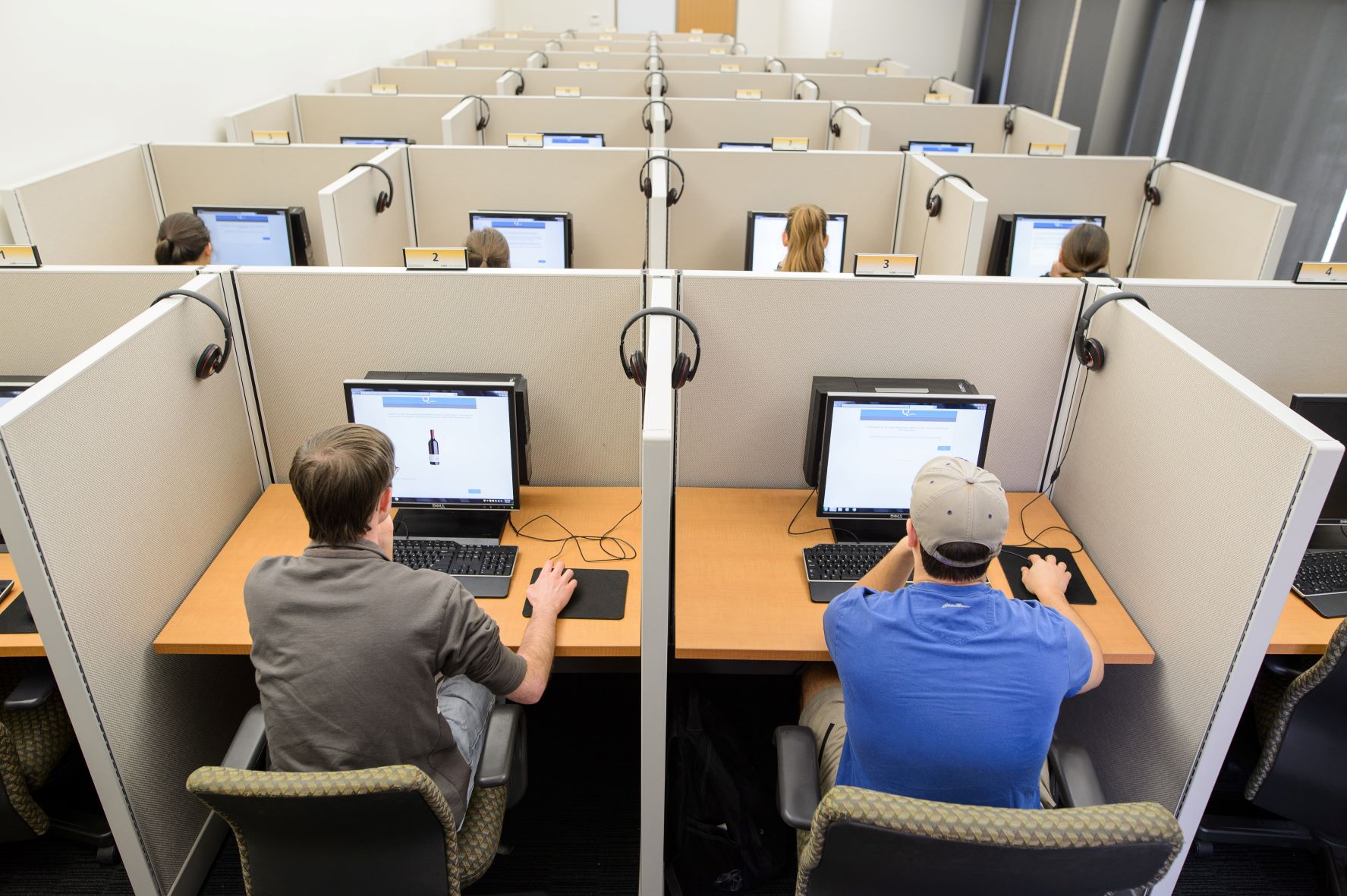 Overhead shot of small cubicles with computers and people working at them.