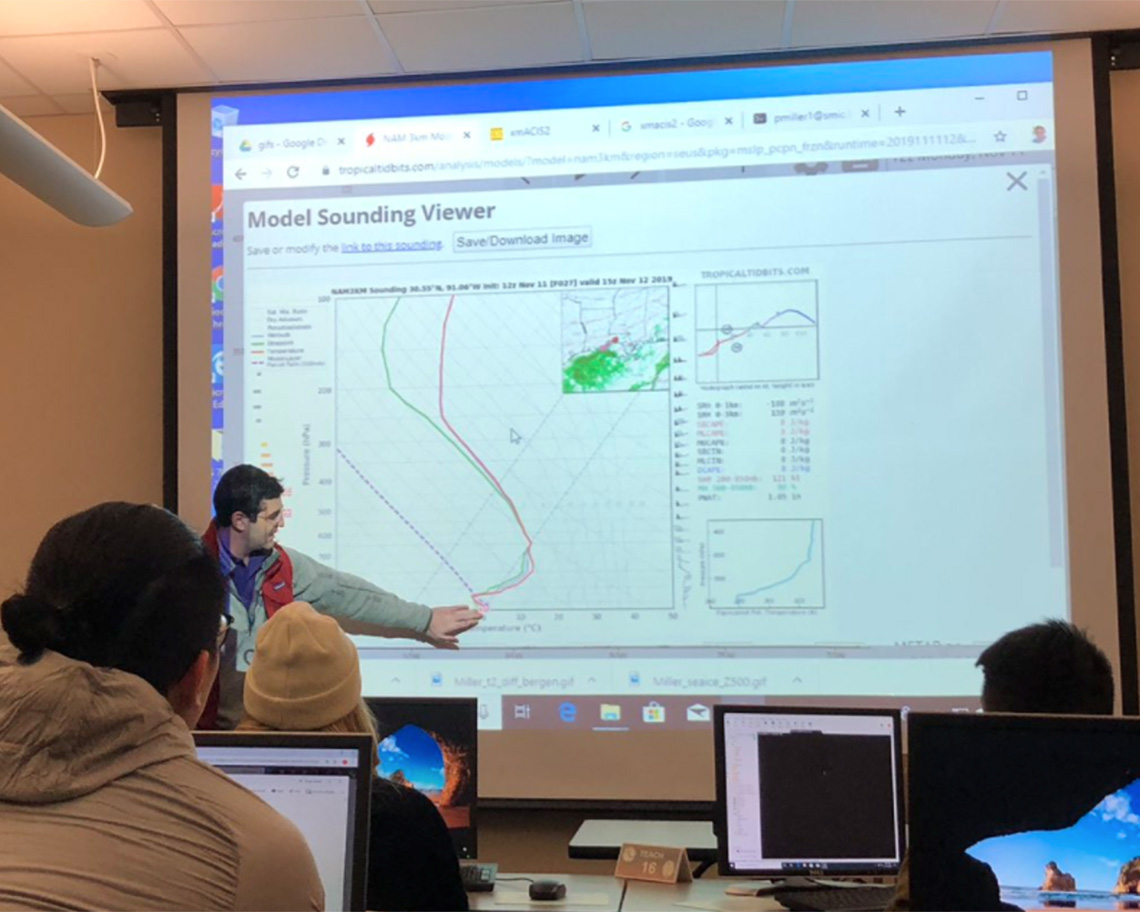 a man points at a graph on a screen