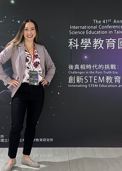 Emily Dare in front of a Japanese Conference backdrop