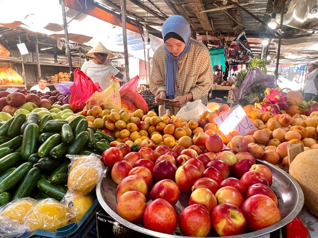 woman at a produce stall in a bazaar
