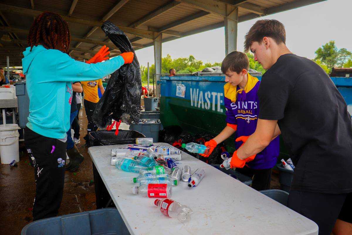 A group of people sorting through waste at the sortation center.