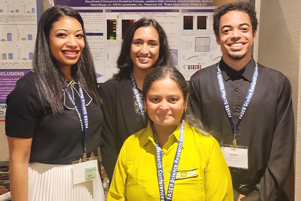 Dr. Alexandra Noel with graduate students in front of a research poster